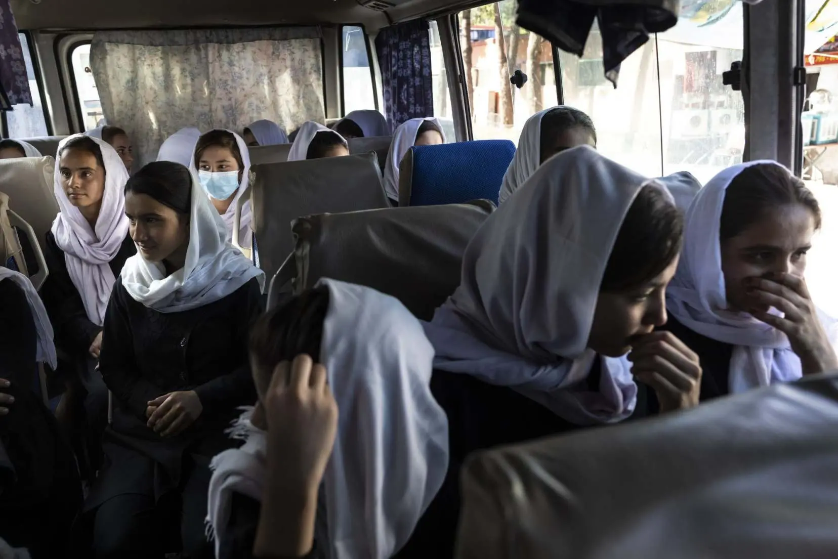 Girls sit together on a bus