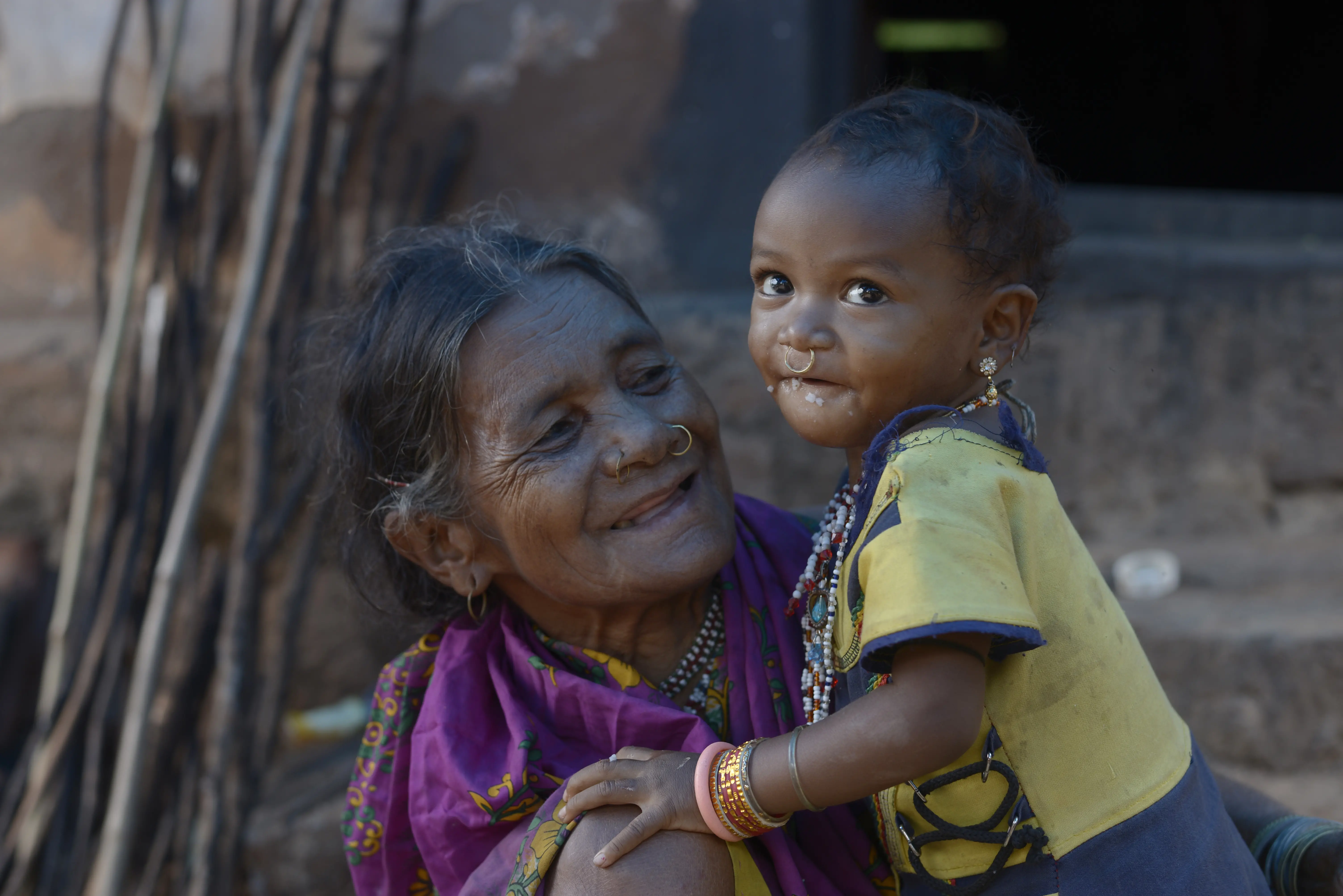 A grandmother holds her young granddaughter