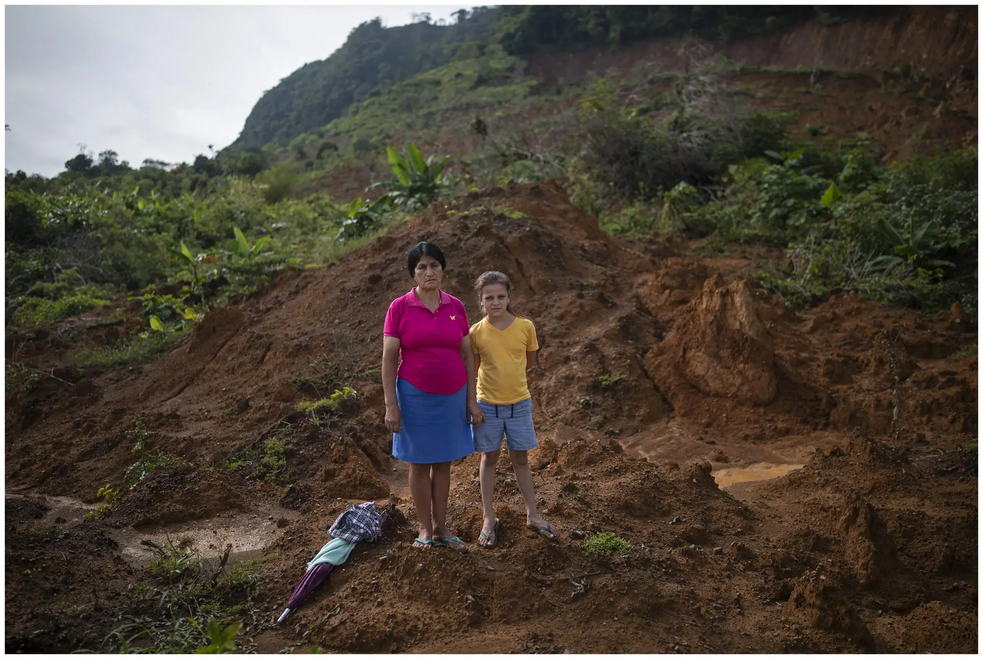 A woman and her granddaughter stand at site of where there home used to be