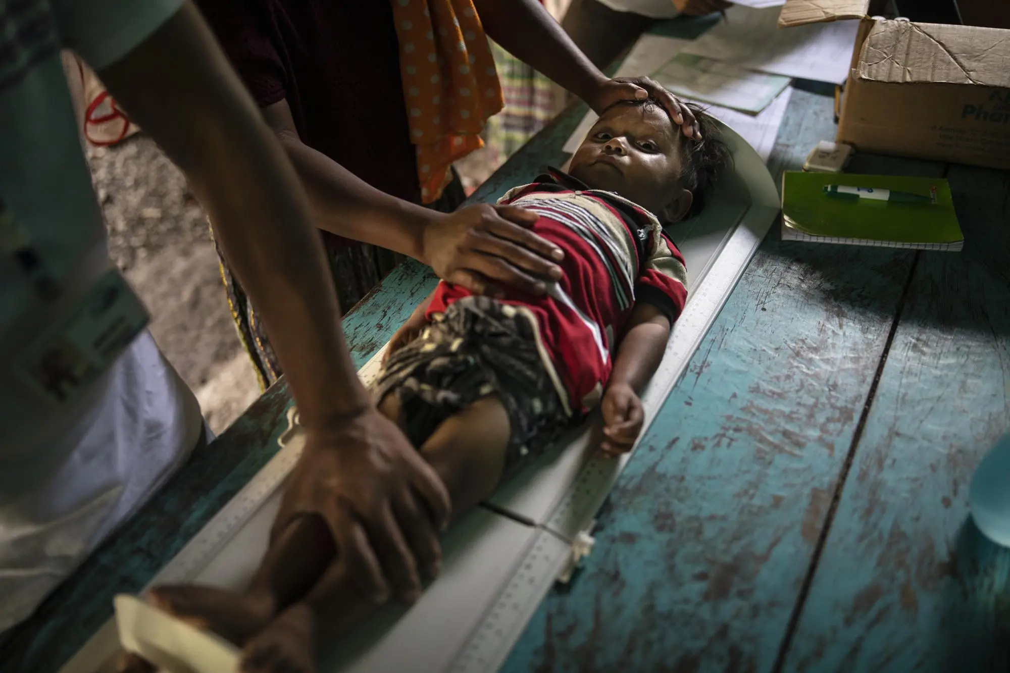 A child goes for a wellness check-up and is laying on a bed
