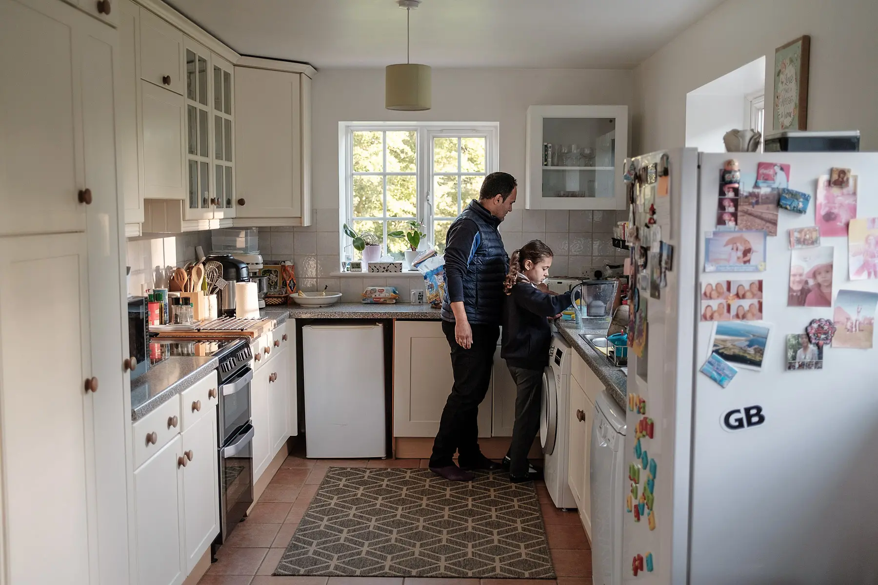A dad and daughter cook together in kitchen