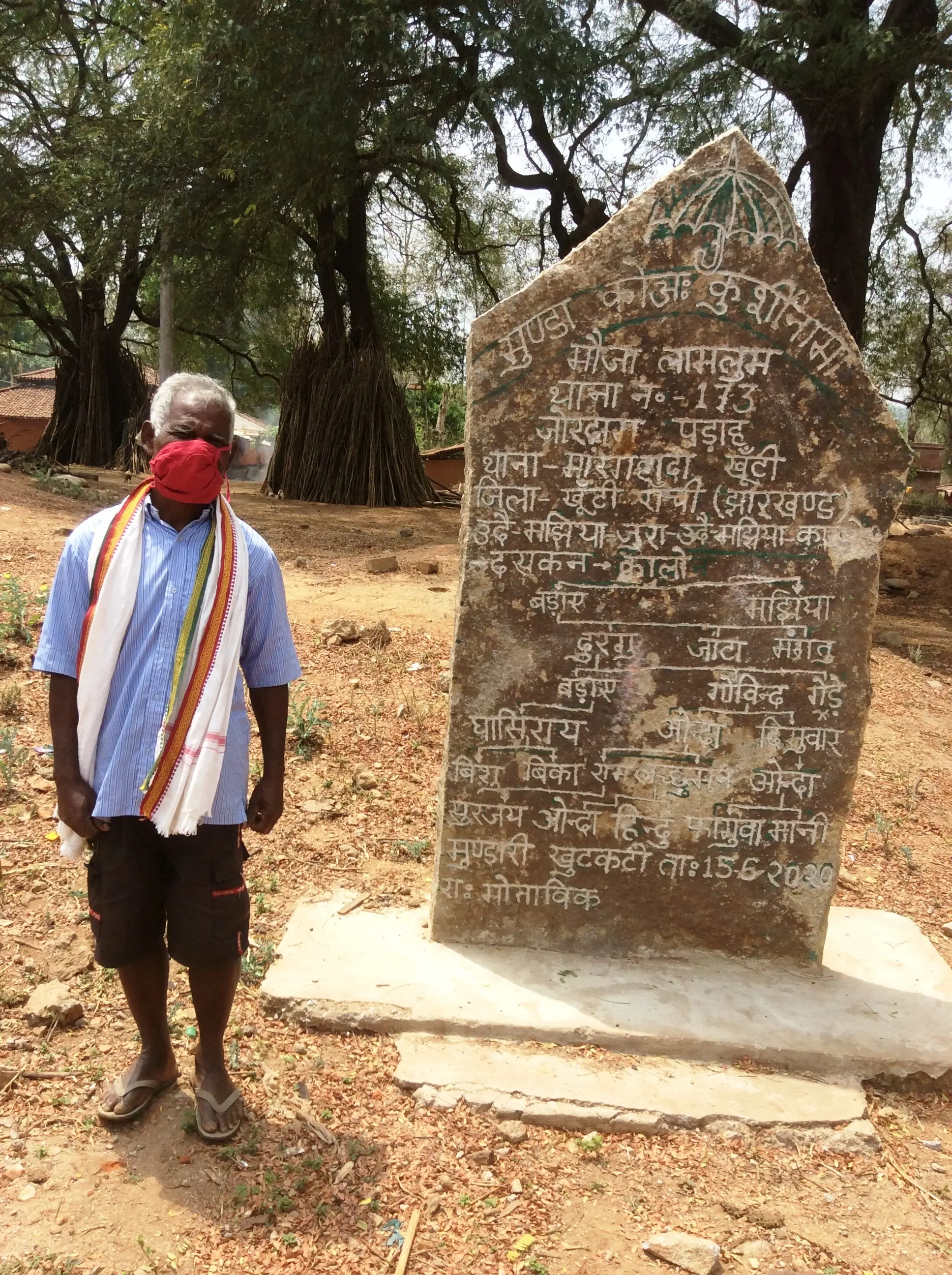 Man stands in front of erected stone slab
