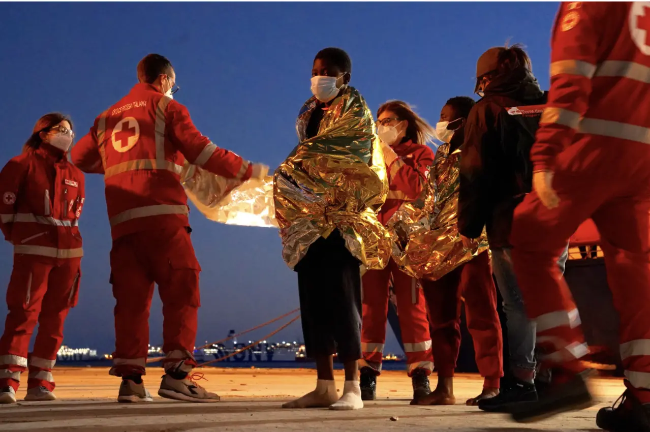 People rescued from faltering boats in the Mediterranean disembark from a rescue ship in Sicily.