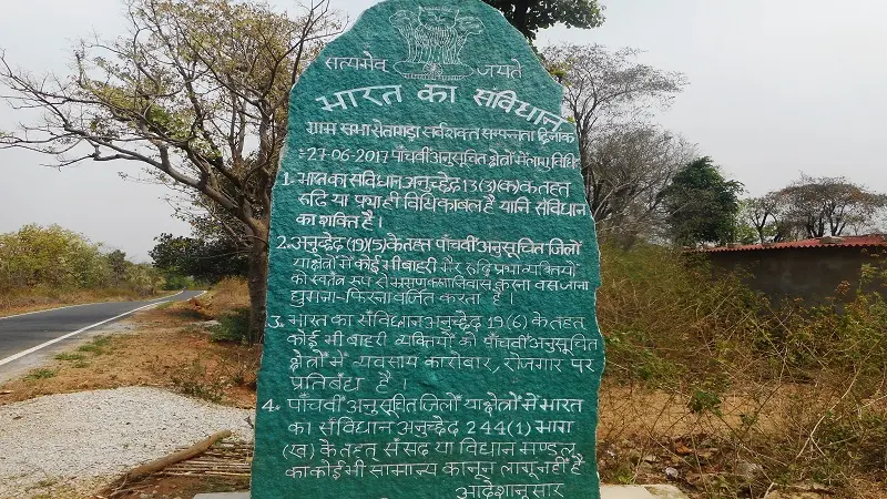 Photo of green stone with text.