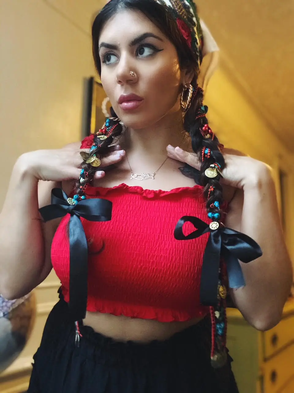 A portrait of Naomi Puzzello with ribbons in her braided hair.