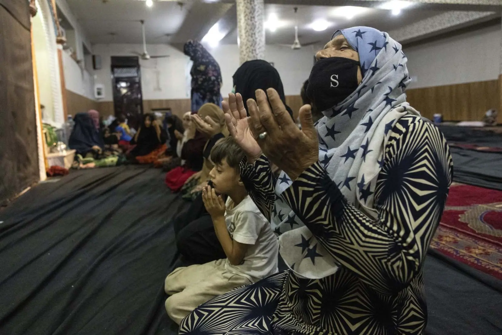 A woman and her child pray at a mosque in Kabul
