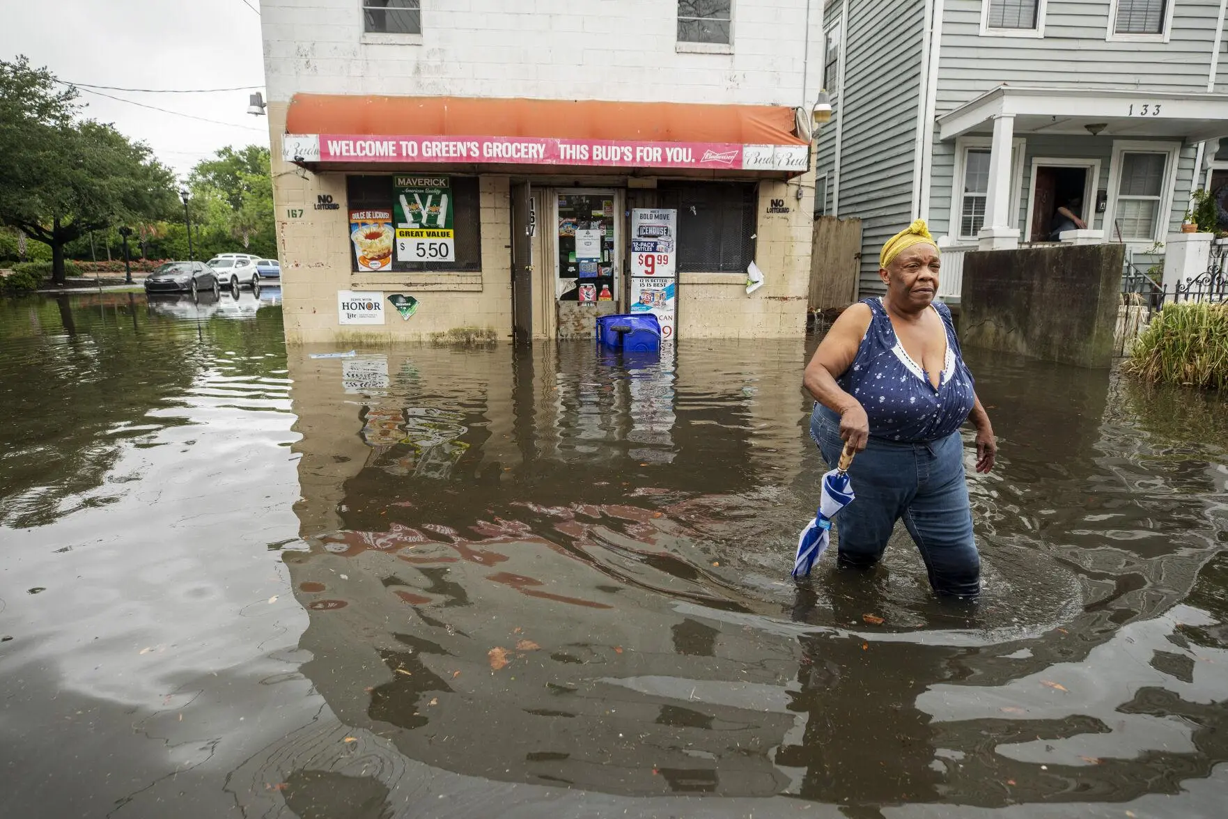 A woman walks through the flood waters in Charleston outside a corner store