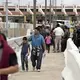 Migrants walk across International Bridge Two into Mexico from Laredo. They requested asylum in the United States but were returned to Mexico to await their court proceedings. Image by Miguel Gutierrez Jr. United States, 2019.