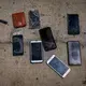 Phones and other items are placed on the ground by police officers as they inspect a boat where 15 Malians were found dead adrift in the Atlantic on Thursday, Aug. 20, 2020, in Gran Canaria island, Spain. Image by Emilio Morenatti/AP Photo. Spain, 2020.