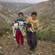 Esmaiel Karimi (left), 12, and his brother Gholamreza, 14, hold baby goats on Zard Mountain, Chahar Mahal and Bakhtiari Province, where they live in the summer. Image by Newsha Tavakolian. Iran, 2018.