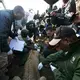  Kenyan and International journalists look on as the Kenya Wildlife Service collars a tranquilized lion. Image by Immanuel Muasya. Kenya, 2017.