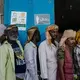 Yemeni men stand in line waiting for a weekly food distribution in Fayoush. Image by Alex Potter. Yemen, 2018. 