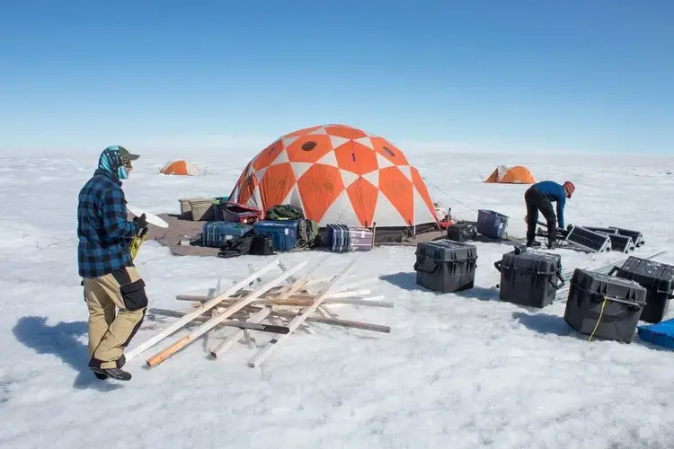 University of Montana glaciologists Joel Harper and Toby Meierbachtol assemble the gear they're using to measure the movement of the ice sheet. Image by Amy Martin. Greenland, 2018. 