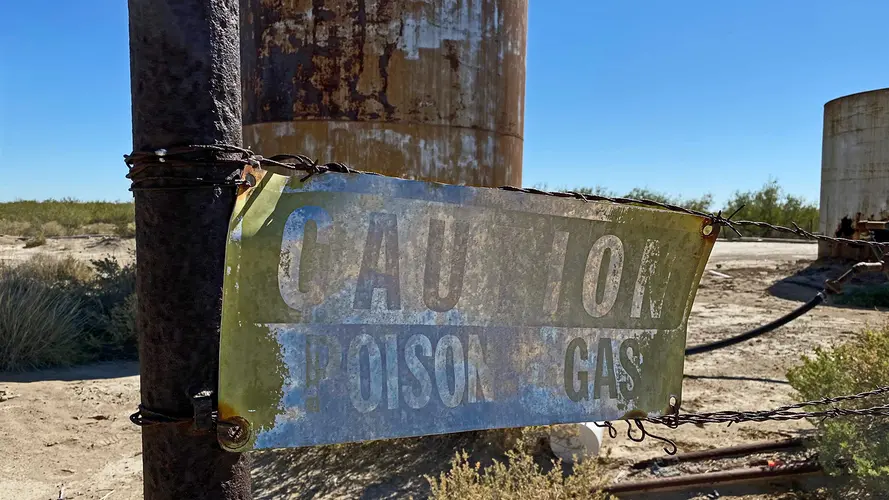 An old, worn sign that reads "Caution Poisonous Gas".