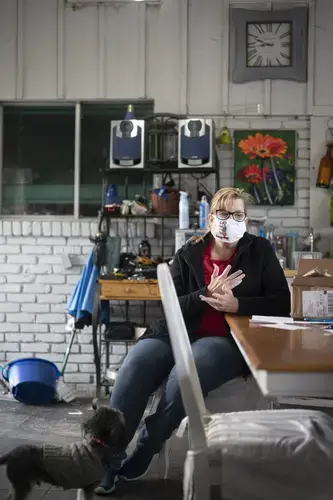 Teri Johnson, president of the Calcasieu Federation of Teachers and School Employees, sits in her temporary office in her home. The teachers’ union office was destroyed by Hurricane Laura. Image by Katie Sikora. United States, 2020.<br />
