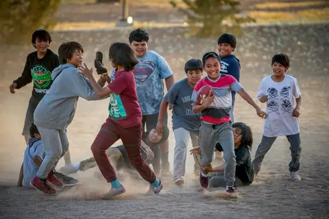 Children play football in Tuba City on the Navajo Nation. Image by Mary F. Calvert. United States, 2020.