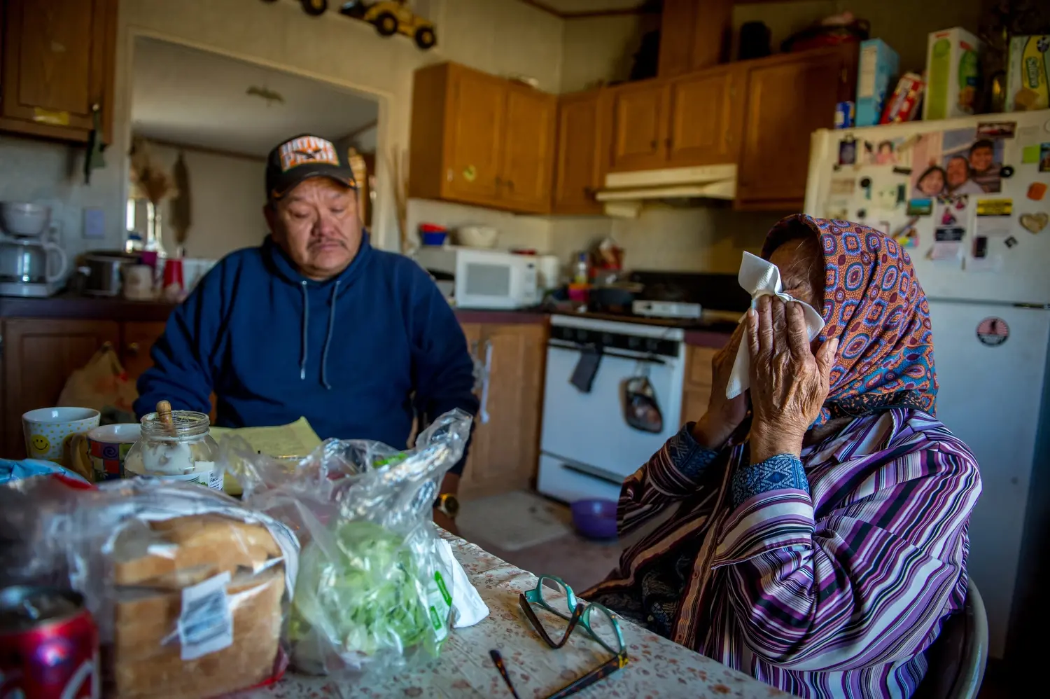 Aaron Yazzie and Helen Nez sit at a kitchen table.