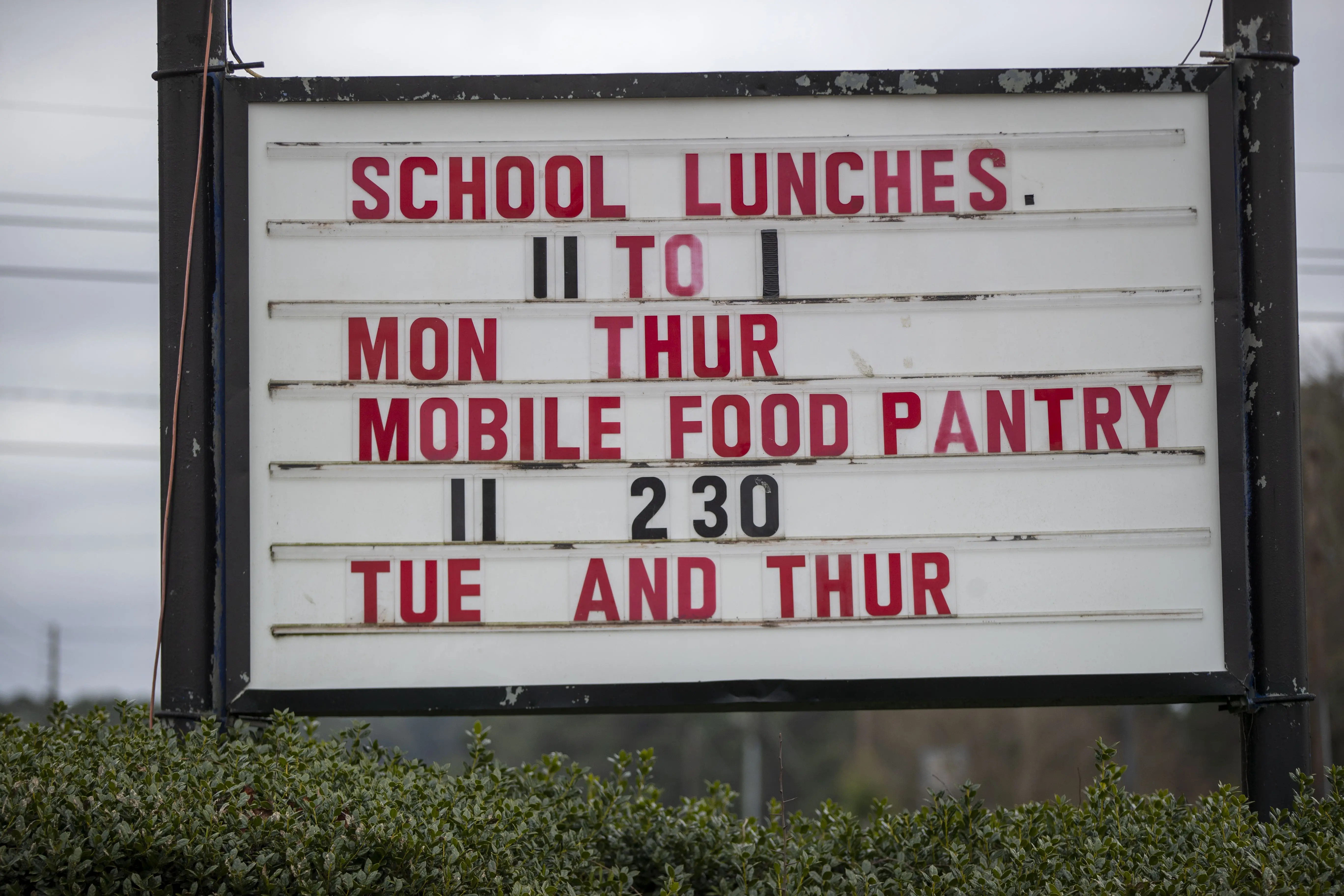 Sign reading "School lunches. 11 to 1 Mon Thur<br />
Mobile food pantry 11 to 2:30<br />
Tue and Thur