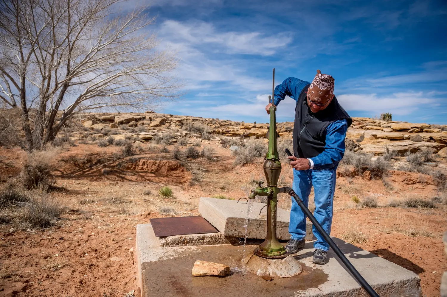 Dariel Yazzie pumps water outside. Image by Mary F. Calvert. United States, 2020.