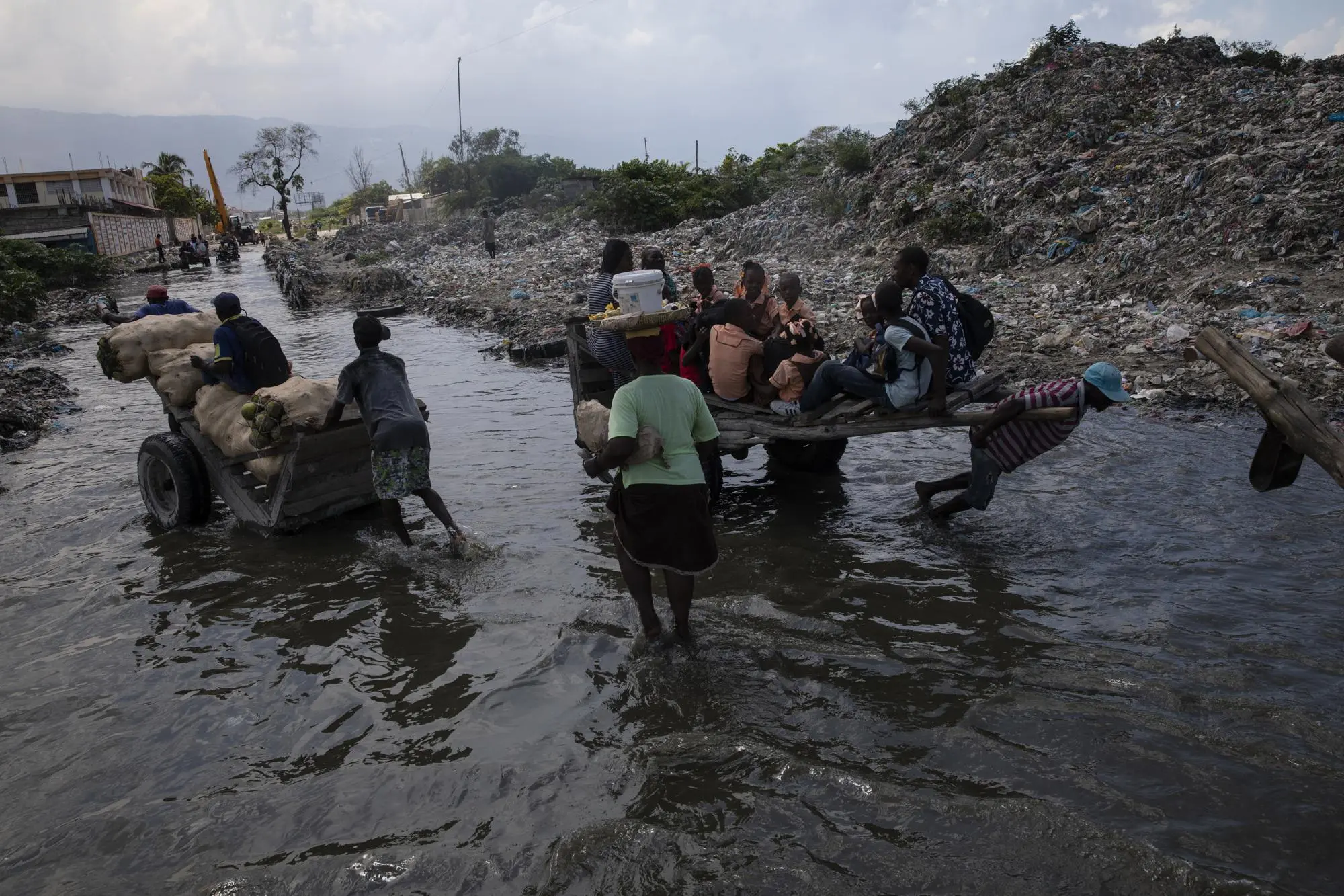 Residents wade through a flooded street in a neighborhood of Port-Au-Prince Haiti