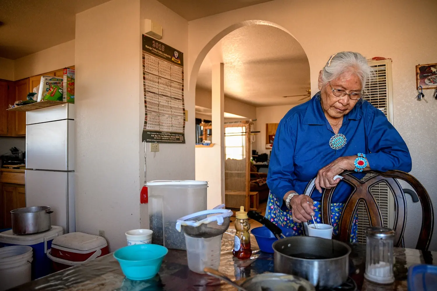 Cecilia Joe stirs her tea at her home near Tuba City, Ariz. Image by Mary F. Calvert. United States, 2020.