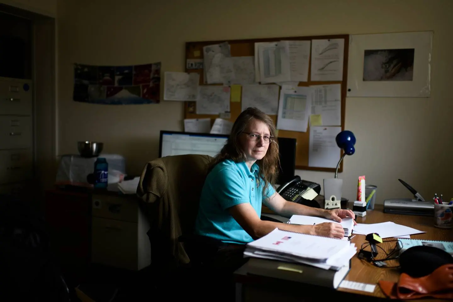 A woman sits at her desk
