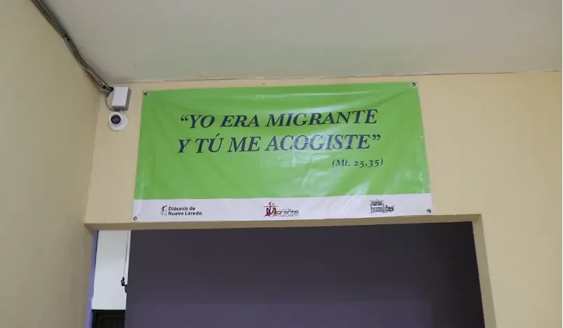 A banner reads "I was a migrant and you welcomed me" in Spanish