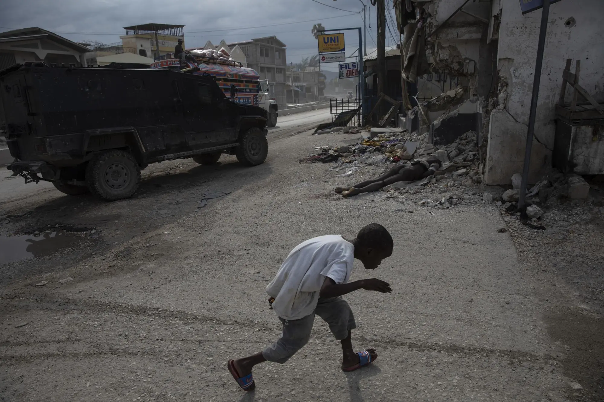 Young boy runs past a dead body in Port-Au-Prince Haiti