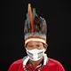 Indigenous leader Jose Augusto, 48, of the Miranha indigenous ethnic group, poses for a portrait wearing the traditional dress of his tribe and a face mask amid the spread of the new coronavirus at the Park of Indigenous Nations community in Manaus, Brazil, Thursday, May 28, 2020. Image by Felipe Dana / AP Photo. Brazil, 2020.